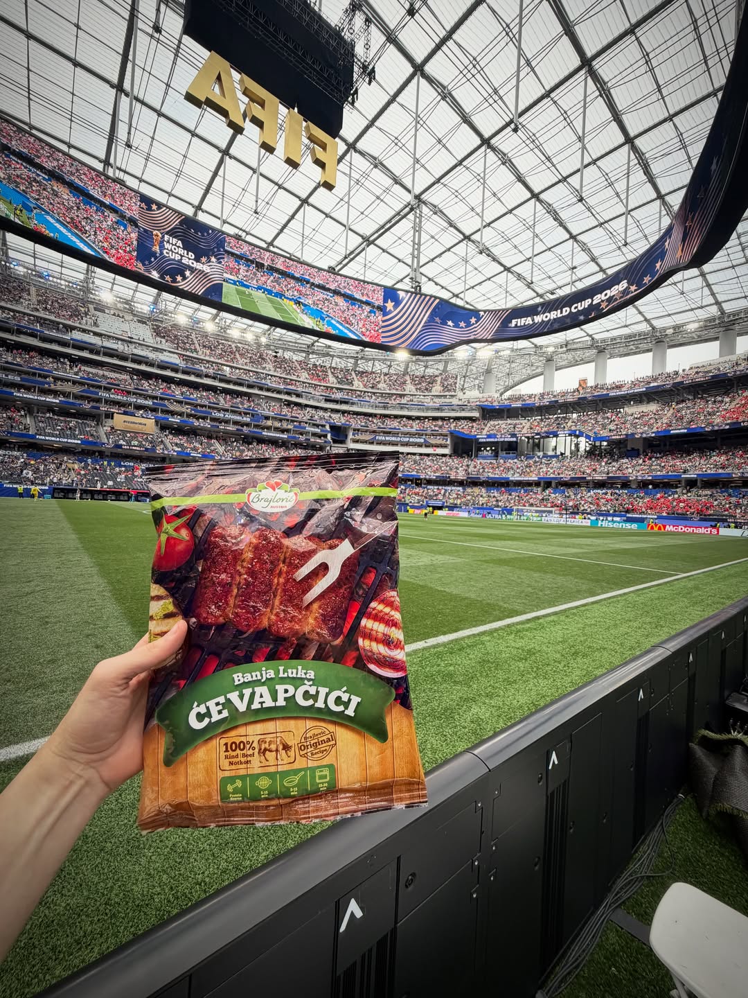 Packung Brajlović Ćevapčići, hochgehalten in einem Stadion